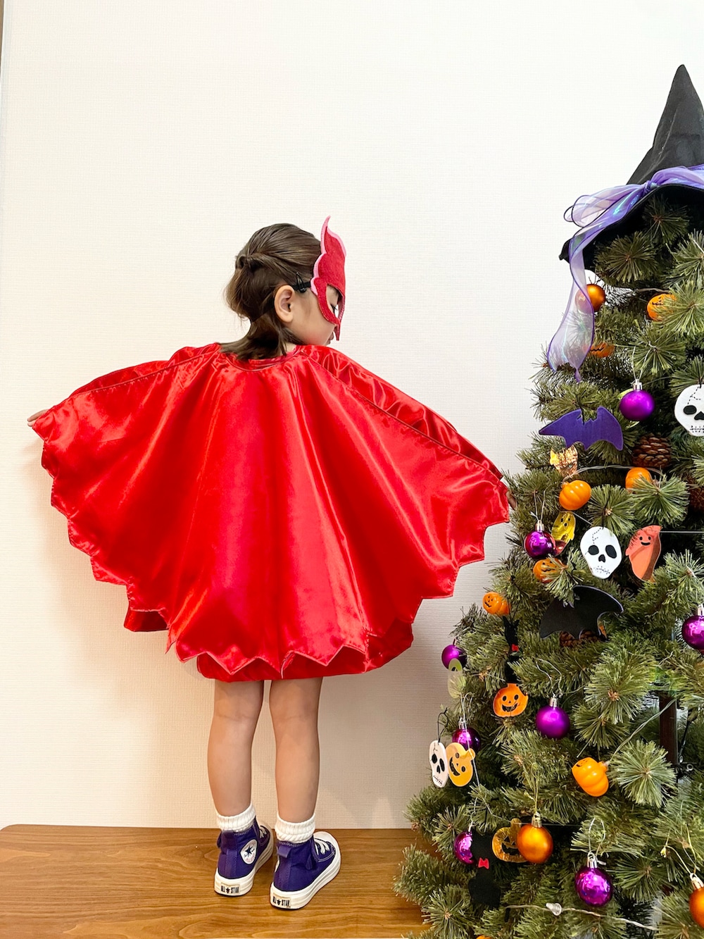 パープル系のスニーカー、レッド系のワンピースを着用したキッズの秋コーディネートの3枚目の写真