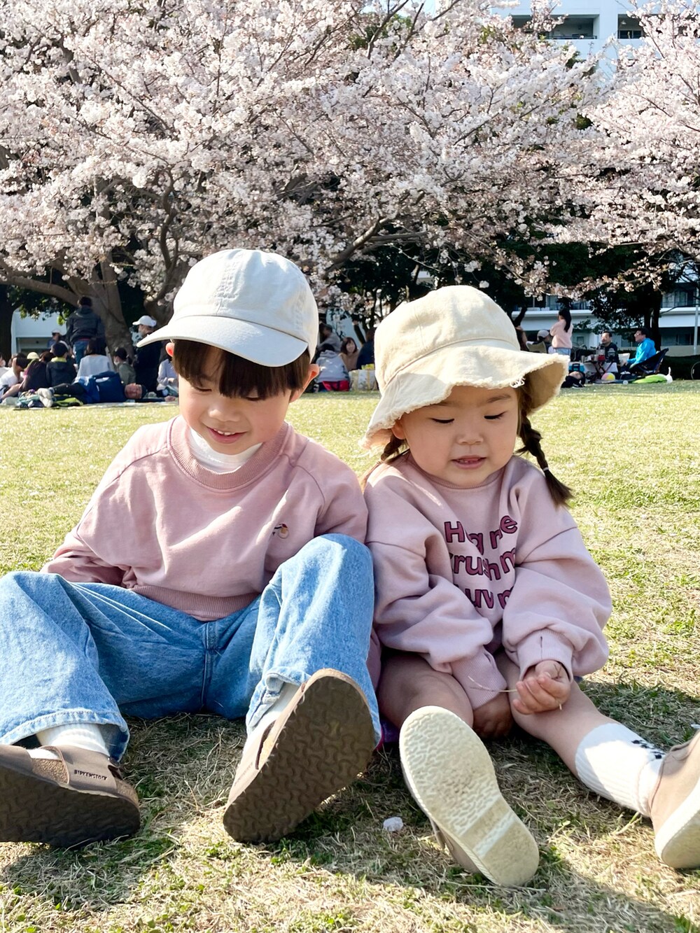 ピンク系のスウェット、ブルー系のデニムパンツ、ブラウン系のサンダルを着用したキッズの春コーディネートの2枚目の写真