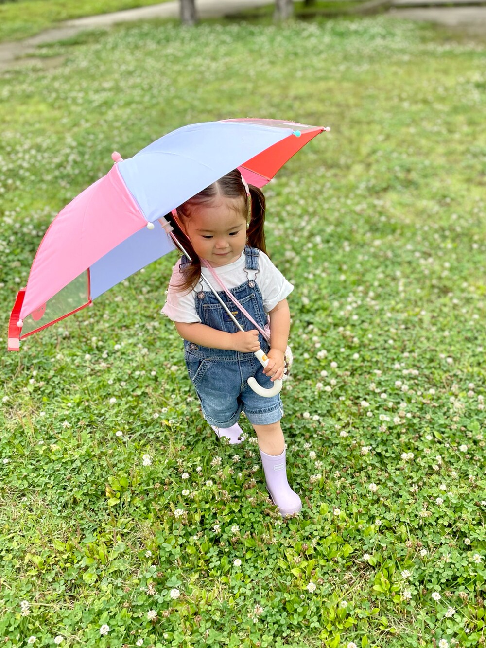 ブルー系のサロペット/オーバーオール、パープル系のレインシューズ、ピンク系のショルダーバッグを着用したキッズの夏コーディネートの2枚目の写真