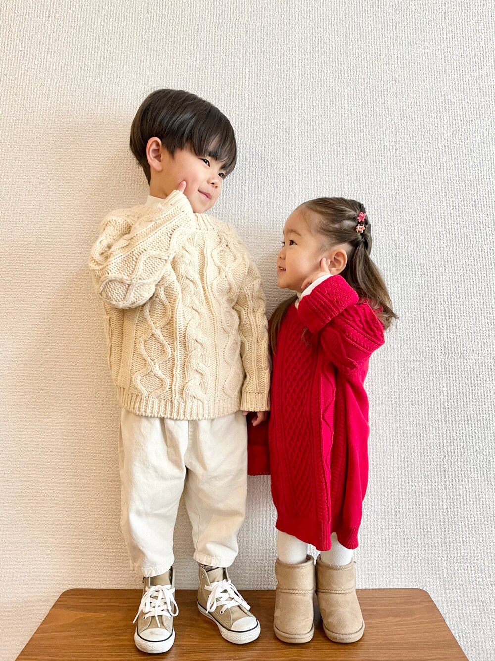 レッド系のニット/セーター、ベージュ系のブーツ、ベージュ系のカーディガン/ボレロを着用したキッズの冬コーディネートの2枚目の写真