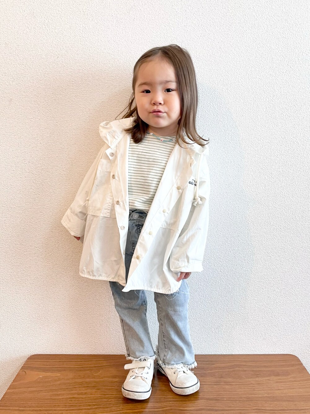 ホワイト系のマウンテンパーカー、グリーン系のTシャツ/カットソー、ブルー系のデニムパンツを着用したキッズの春コーディネートの2枚目の写真