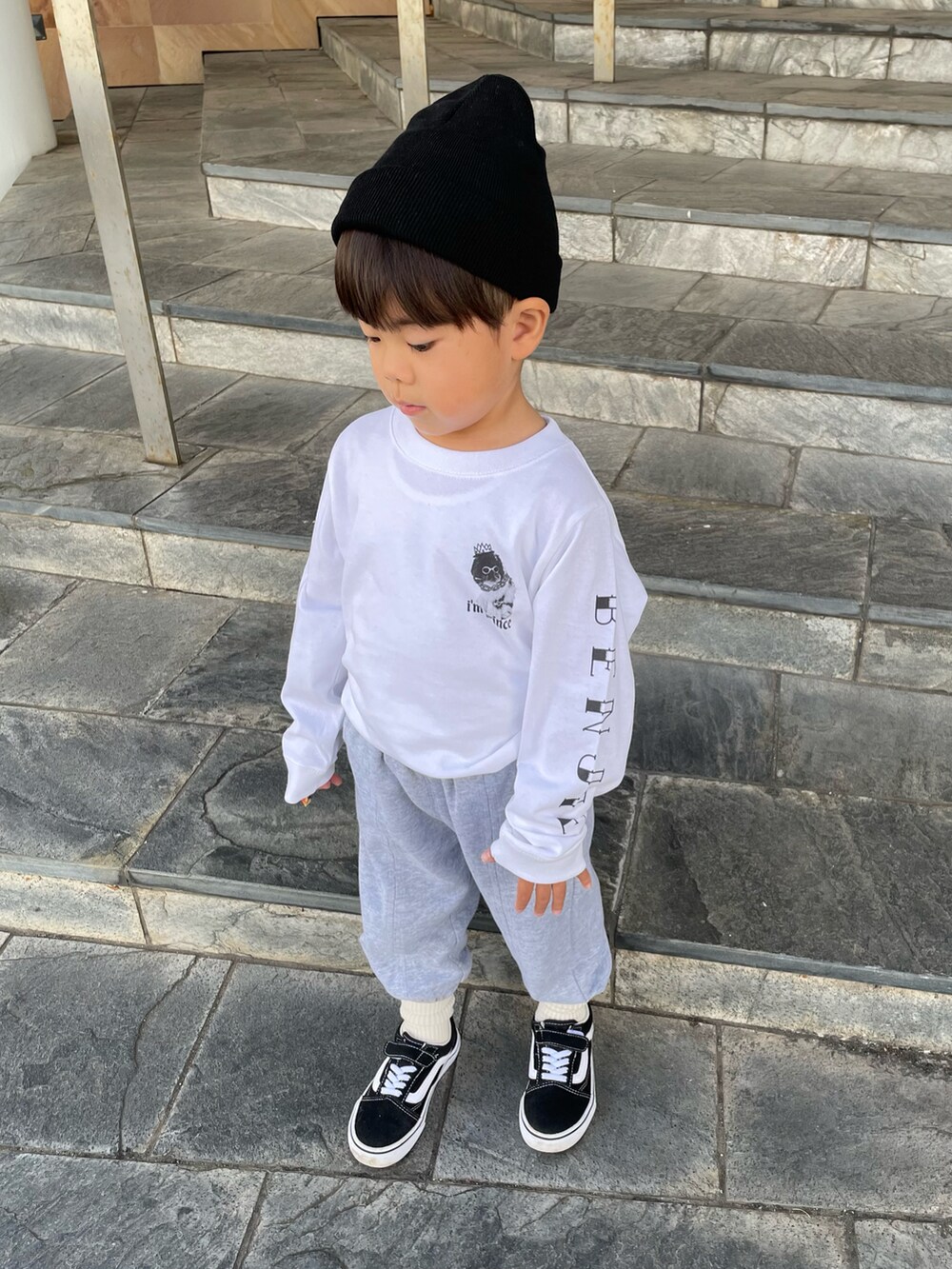 ホワイト系のTシャツ/カットソー、グレー系のスラックス、ブラック系のスニーカーを着用したキッズの秋コーディネートの3枚目の写真