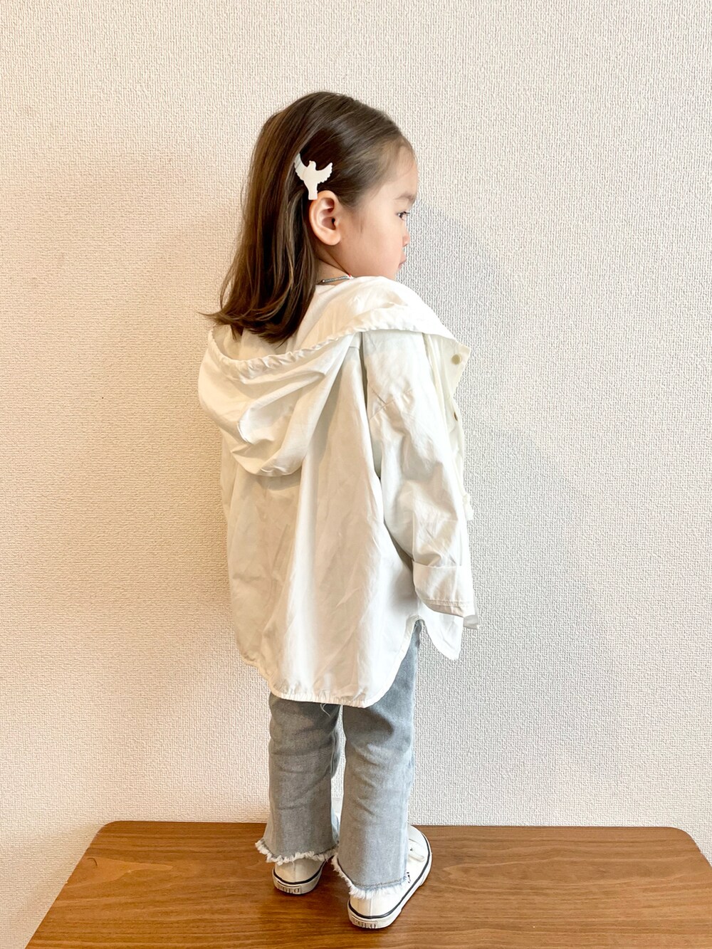 ホワイト系のマウンテンパーカー、グリーン系のTシャツ/カットソー、ブルー系のデニムパンツを着用したキッズの春コーディネートの4枚目の写真