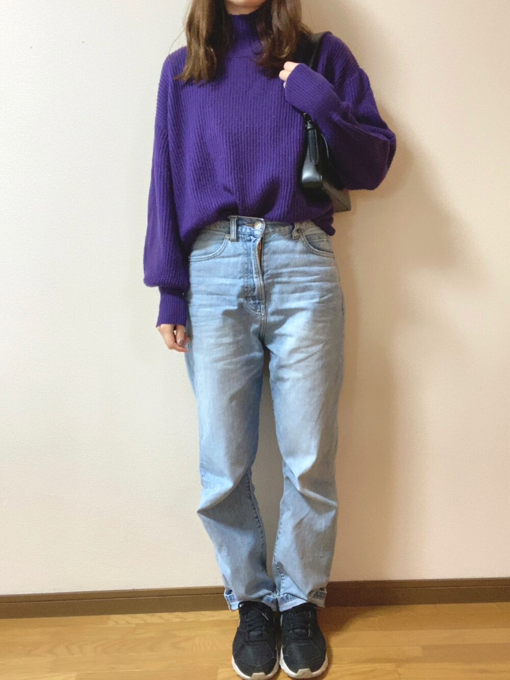 ブラック系のダウンジャケット/コート、ブラック系のショルダーバッグ、ブルー系のデニムパンツを着用したレディースの冬コーディネートの2枚目の写真