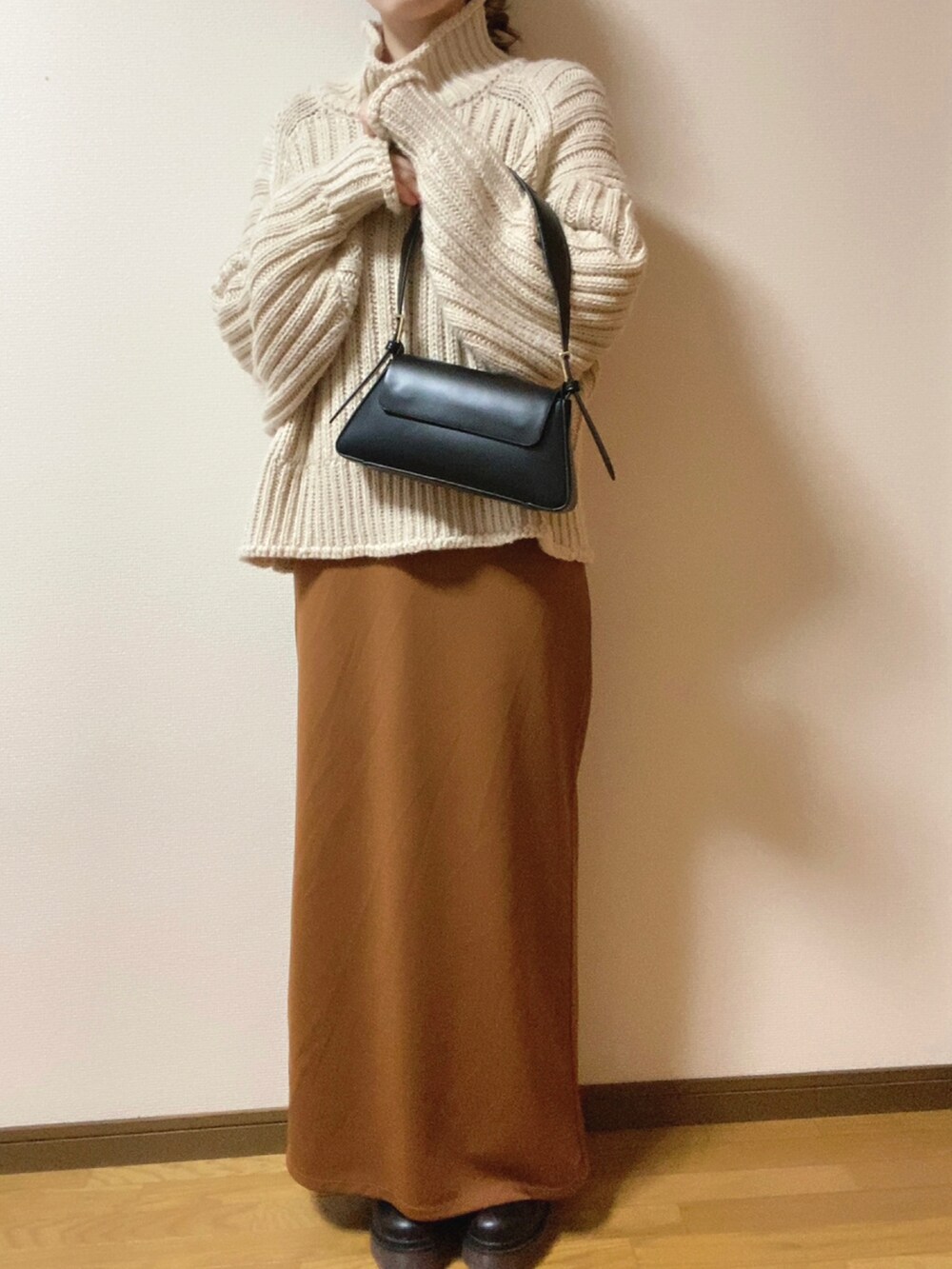 ブラック系のダウンジャケット/コート、ブラック系のショルダーバッグ、ブラウン系のワンピースを着用したレディースの冬コーディネートの3枚目の写真