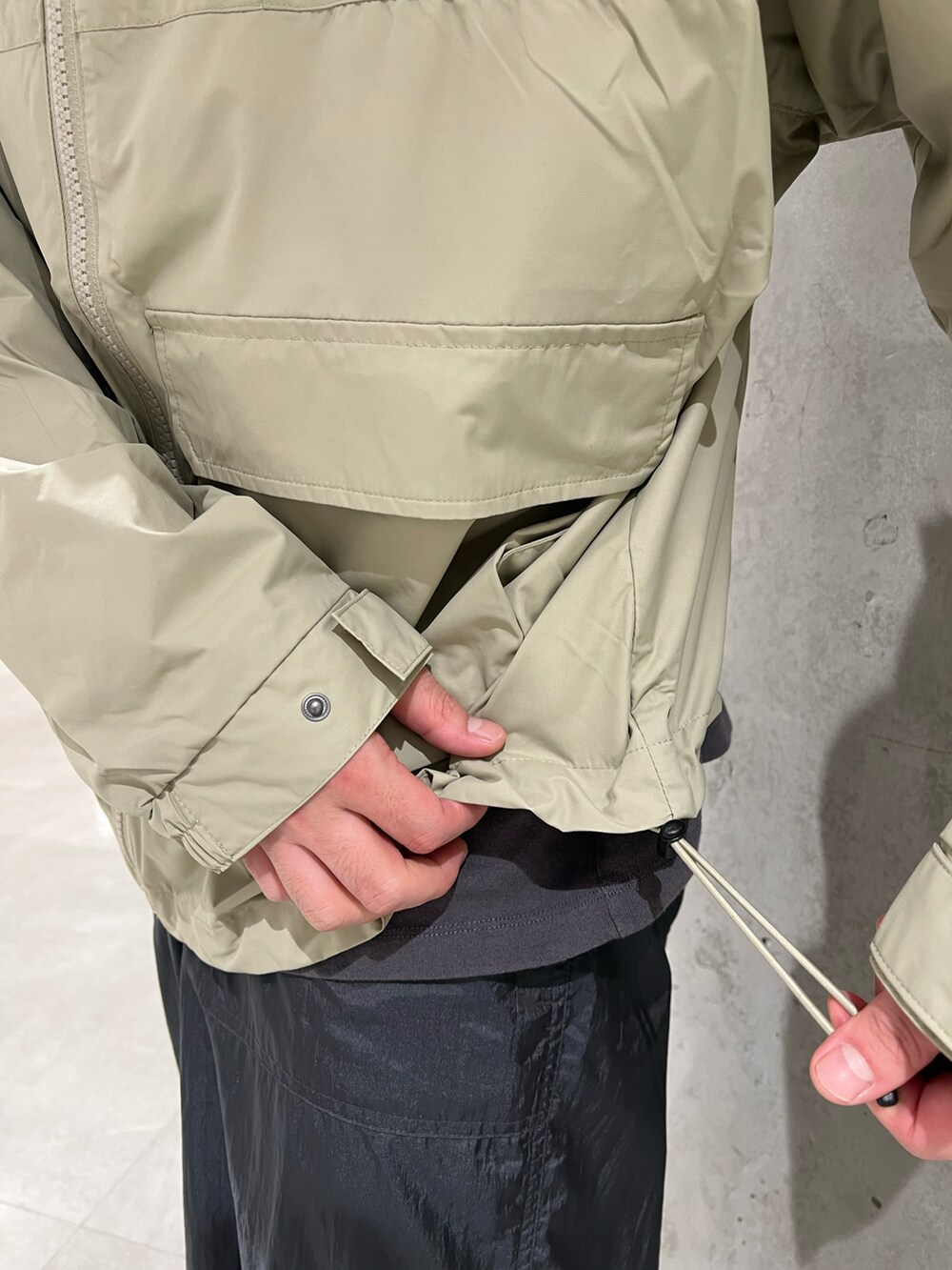 グリーン系のナイロンジャケット、グレー系のTシャツ/カットソー、グレー系のその他パンツを着用したメンズの秋コーディネートの5枚目の写真