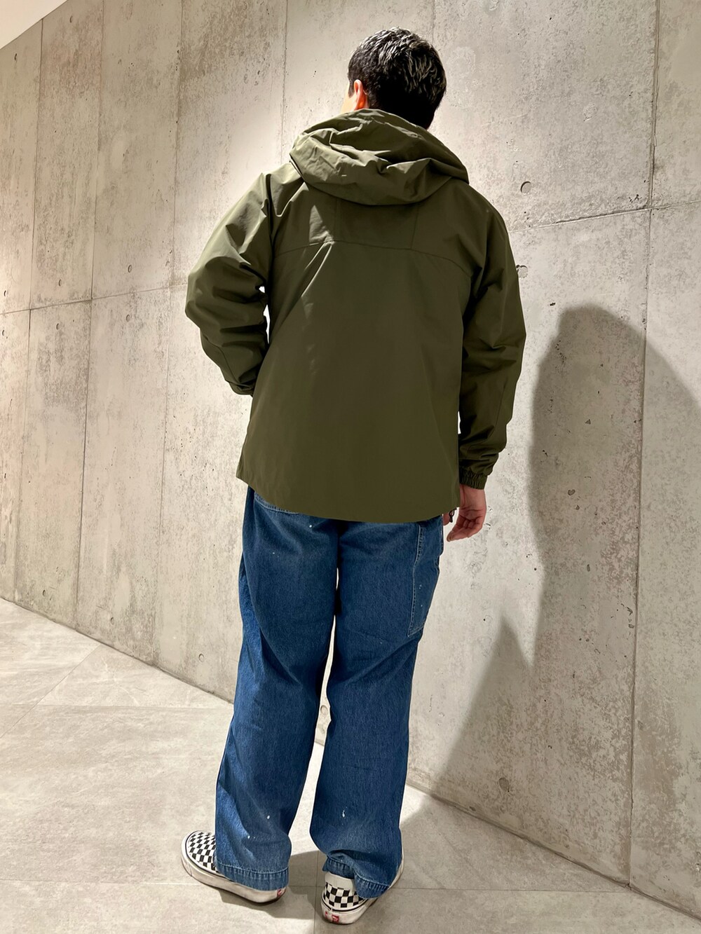 グリーン系のマウンテンパーカー、グレー系のスウェット、その他のスリッポンを着用したメンズの春コーディネートの5枚目の写真