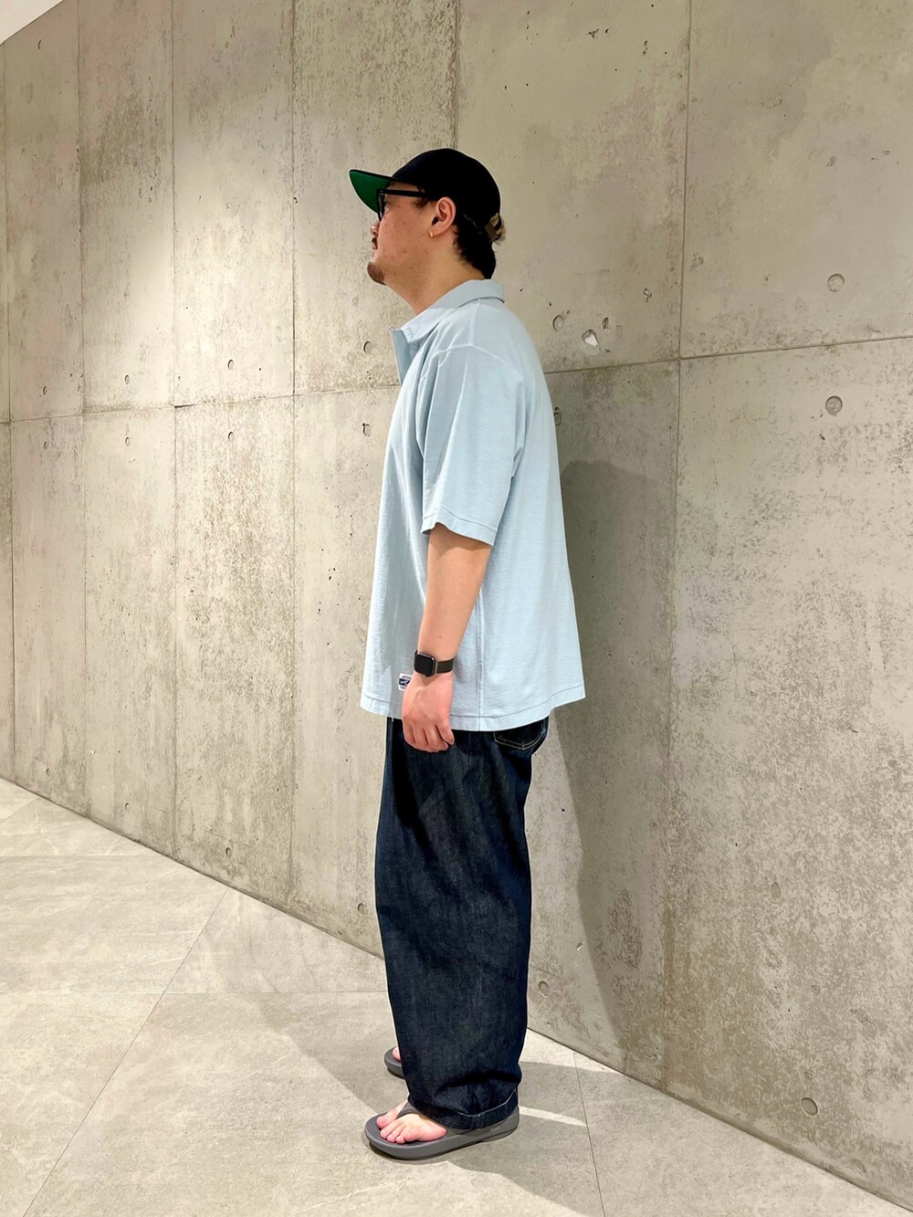 ブルー系のポロシャツ、ブルー系のデニムパンツ、グレー系のサンダルを着用したメンズの春コーディネートの2枚目の写真