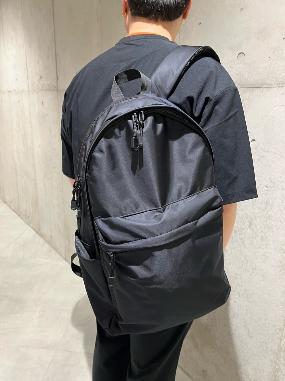 ブラック系のTシャツ/カットソー、オレンジ系のTシャツ/カットソー、ブラック系のその他パンツを着用したメンズの春コーディネートの4枚目の写真