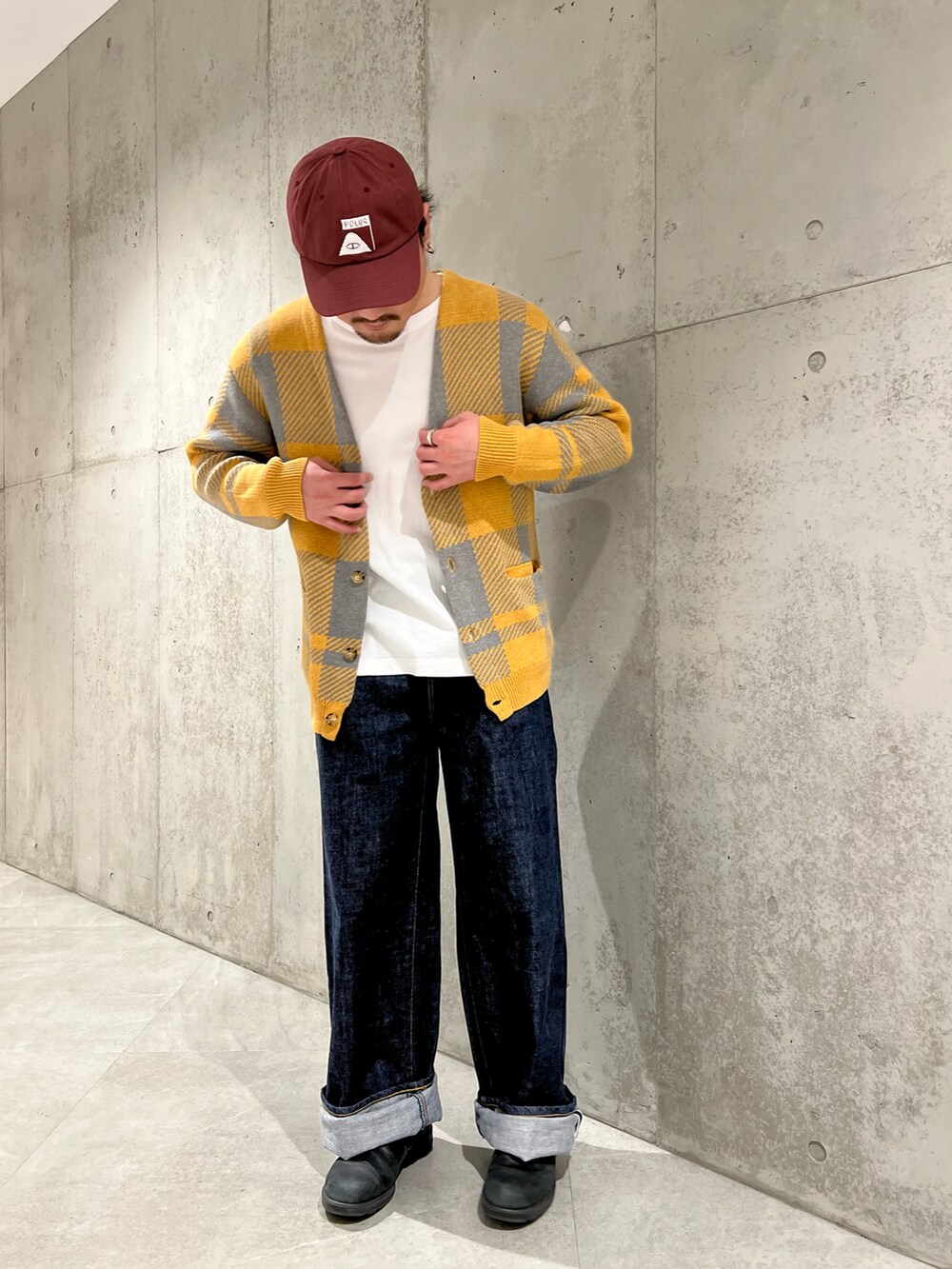 イエロー系のカーディガン/ボレロ、ブルー系のデニムパンツ、ブラック系のスニーカーを着用したメンズの冬コーディネートの2枚目の写真