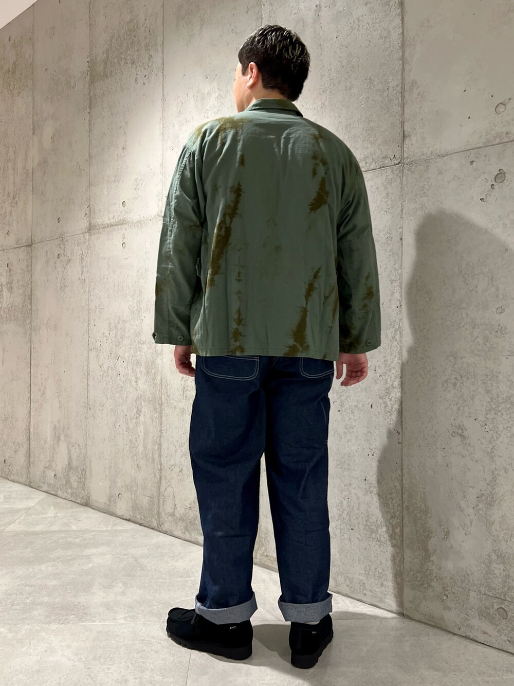 ブルー系のデニムパンツ、ブラック系のブーツ、ブルー系のミリタリージャケットを着用したメンズの春コーディネートの4枚目の写真