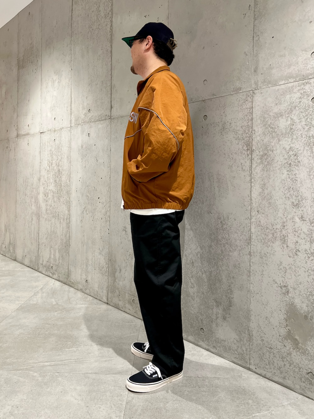 ホワイト系のTシャツ/カットソー、ブラック系のチノパンツ、ブラウン系のブルゾンを着用したメンズの秋コーディネートの3枚目の写真