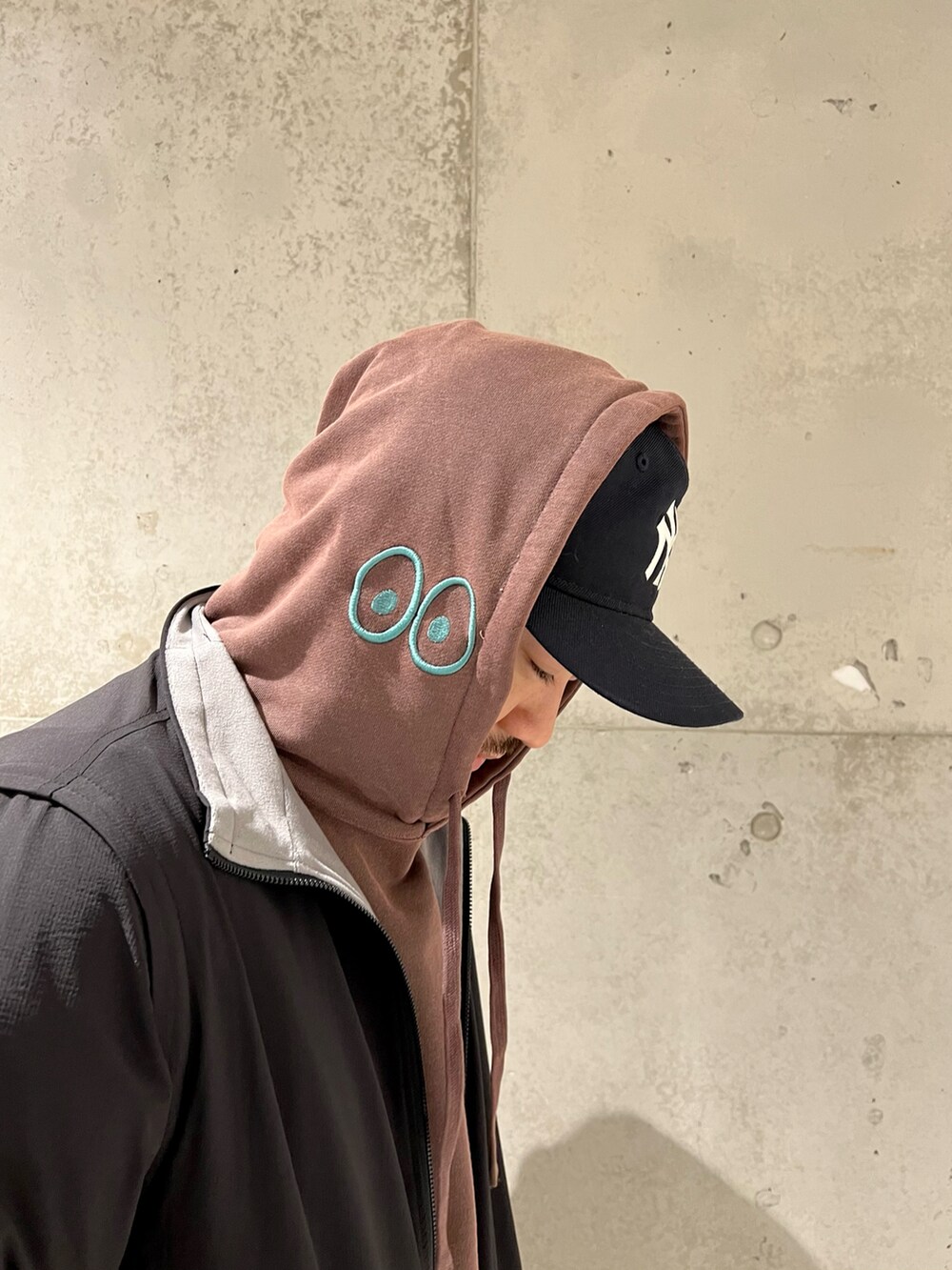 ブラック系のブルゾン、レッド系のパーカー、ブラック系のその他パンツを着用したメンズの冬コーディネートの5枚目の写真