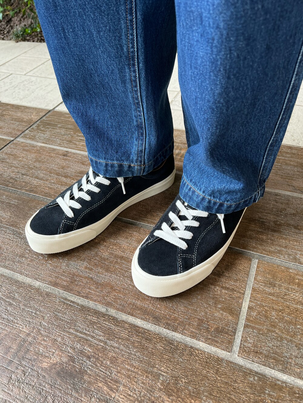 ブラック系のTシャツ/カットソー、ブルー系のデニムパンツ、ブラック系のバックパック/リュックを着用したメンズの春コーディネートの2枚目の写真