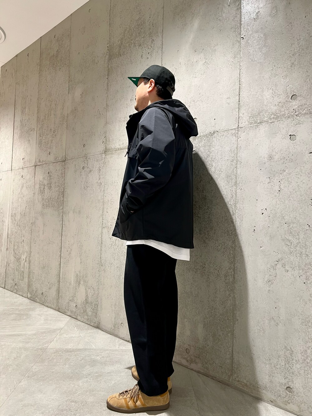 ブラック系のマウンテンパーカー、ブラック系のスウェットパンツ、レッド系のTシャツ/カットソーを着用したメンズの春コーディネートの4枚目の写真