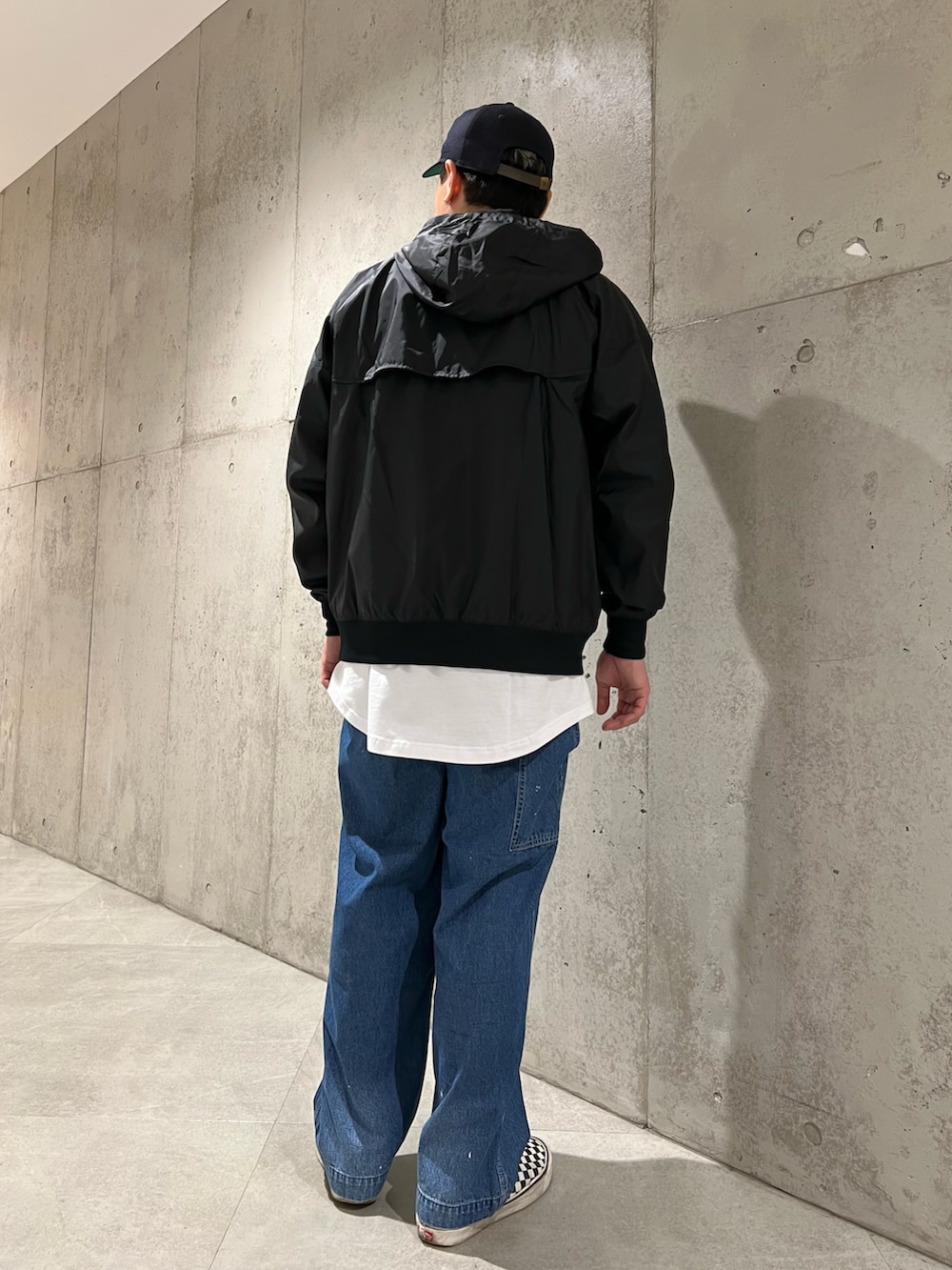 ブルー系のデニムパンツ、ブラック系のブルゾン、ブラック系のTシャツ/カットソーを着用したメンズの春コーディネートの4枚目の写真