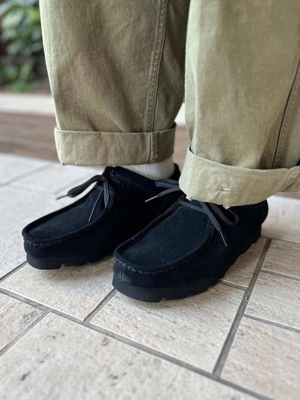 グリーン系のカーゴパンツ、ブラック系のブーツ、ホワイト系のTシャツ/カットソーを着用したメンズの秋コーディネートの5枚目の写真