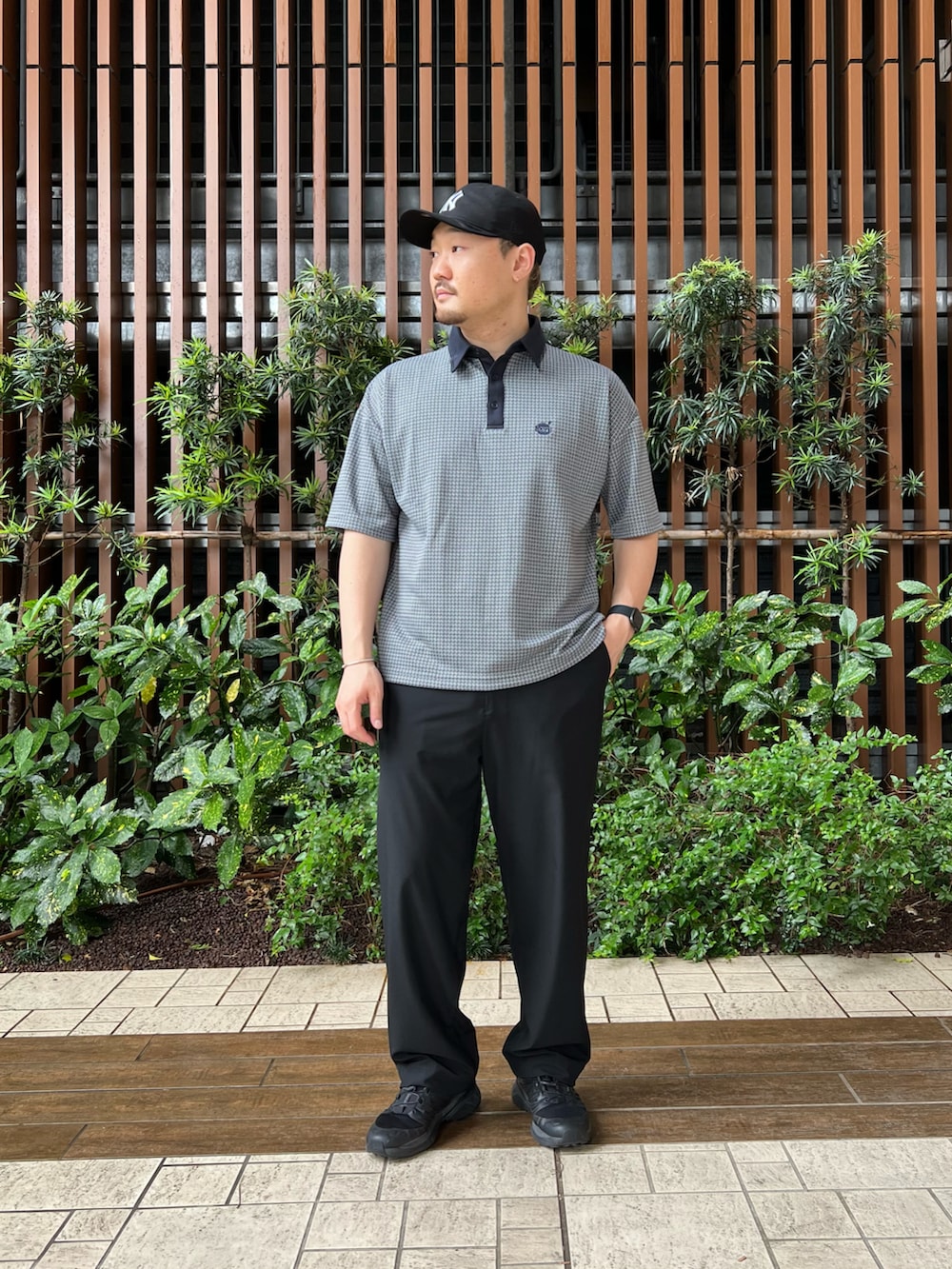 ブラック系のその他パンツ、ブルー系のポロシャツ、ブラック系のシューズを着用したメンズの春コーディネートの2枚目の写真