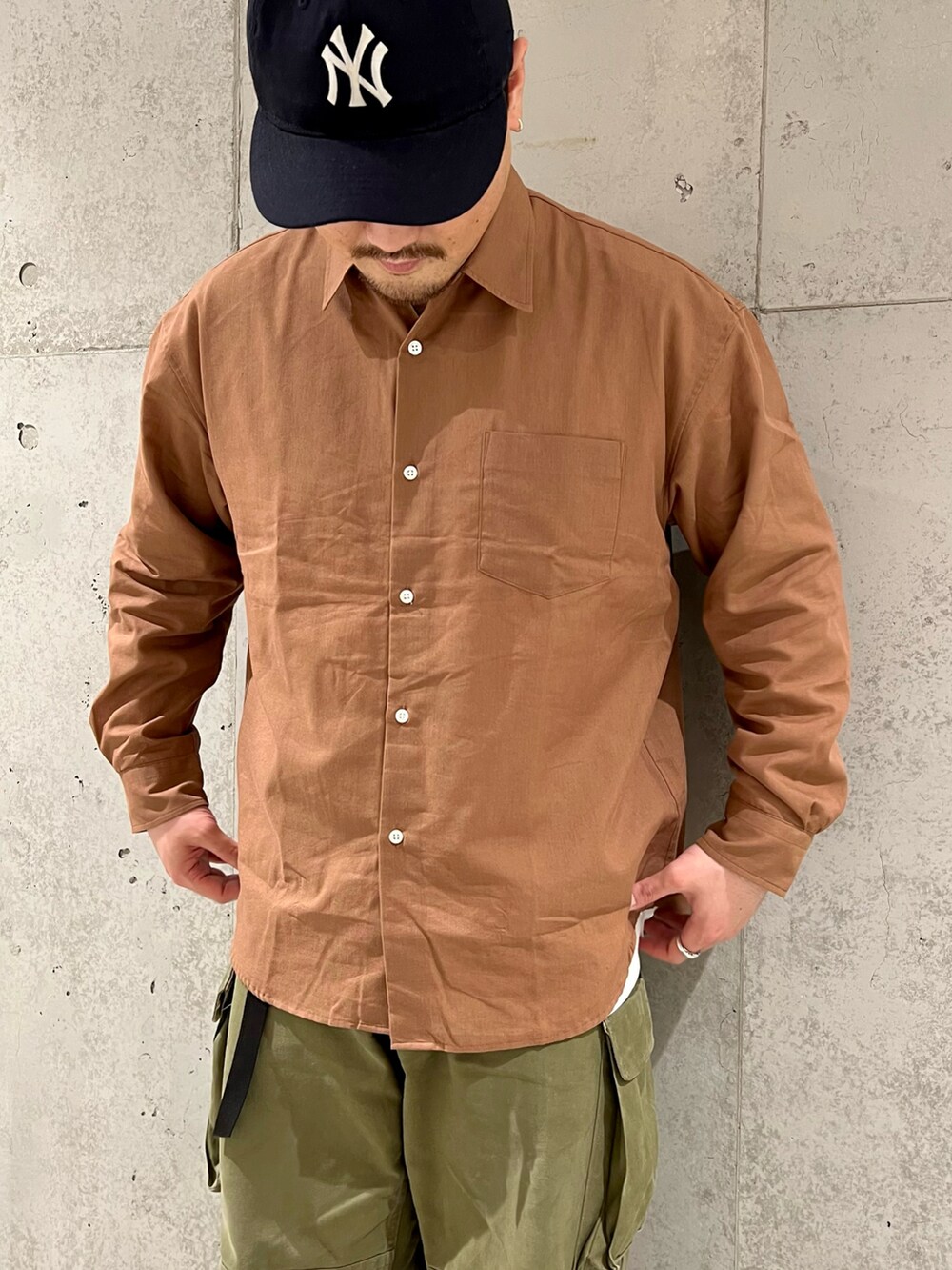 オレンジ系のシャツ/ブラウス、グリーン系のカーゴパンツ、ホワイト系のTシャツ/カットソーを着用したメンズの春コーディネートの2枚目の写真