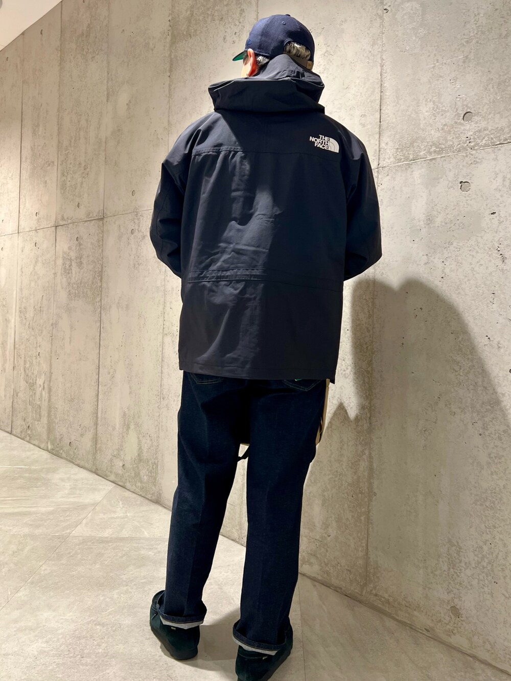 ブラック系のナイロンジャケット、ブルー系のデニムパンツ、ブラック系のブーツを着用したメンズの春コーディネートの4枚目の写真