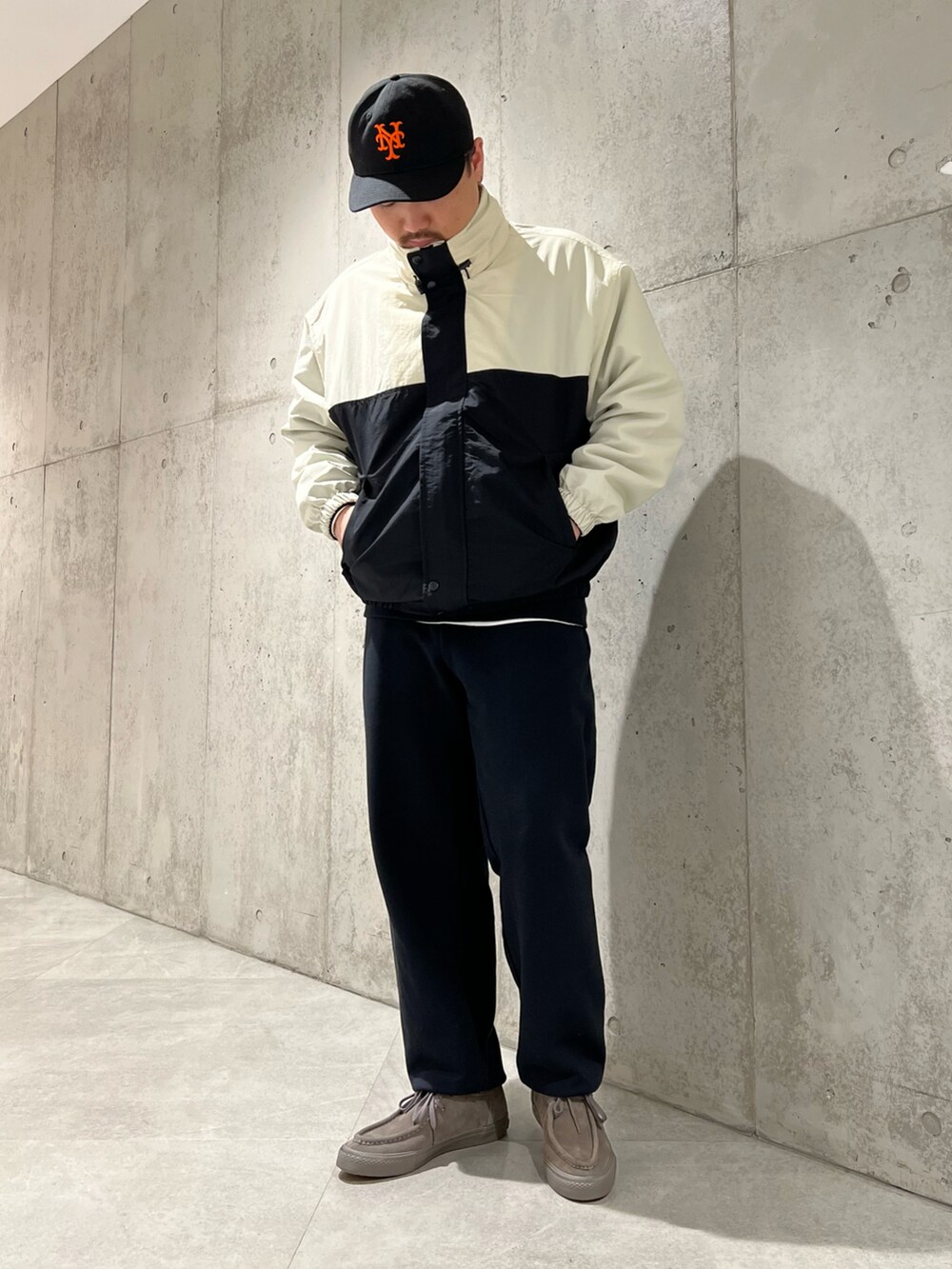 ブラック系のナイロンジャケット、ベージュ系のスニーカー、ブラック系のスウェットを着用したメンズの春コーディネートの2枚目の写真