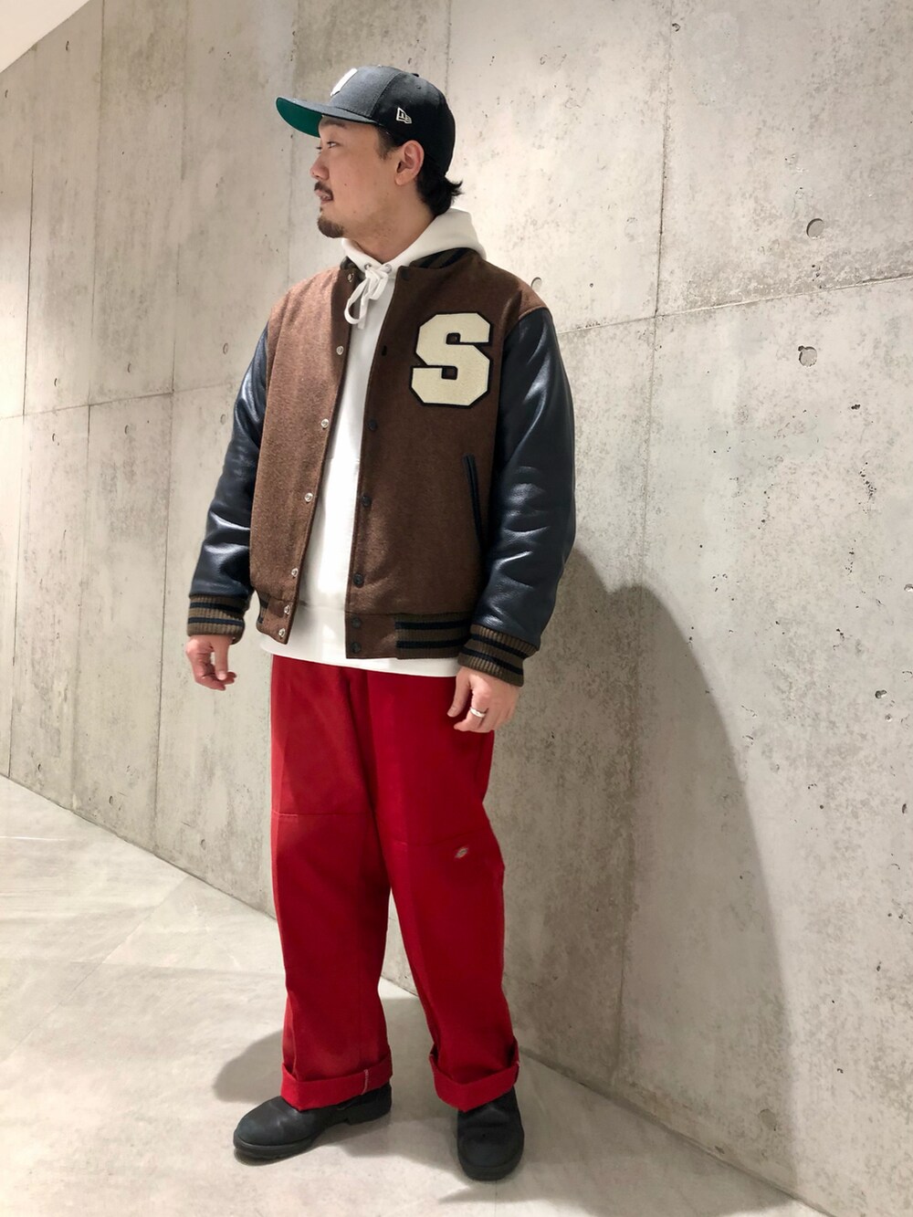 ブラウン系のスタジャン、ホワイト系のパーカー、レッド系のパンツを着用したメンズの秋コーディネートの2枚目の写真