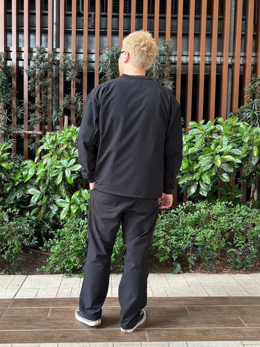ブラック系のスニーカー、ブラック系のその他パンツ、ホワイト系のTシャツ/カットソーを着用したメンズの春コーディネートの5枚目の写真