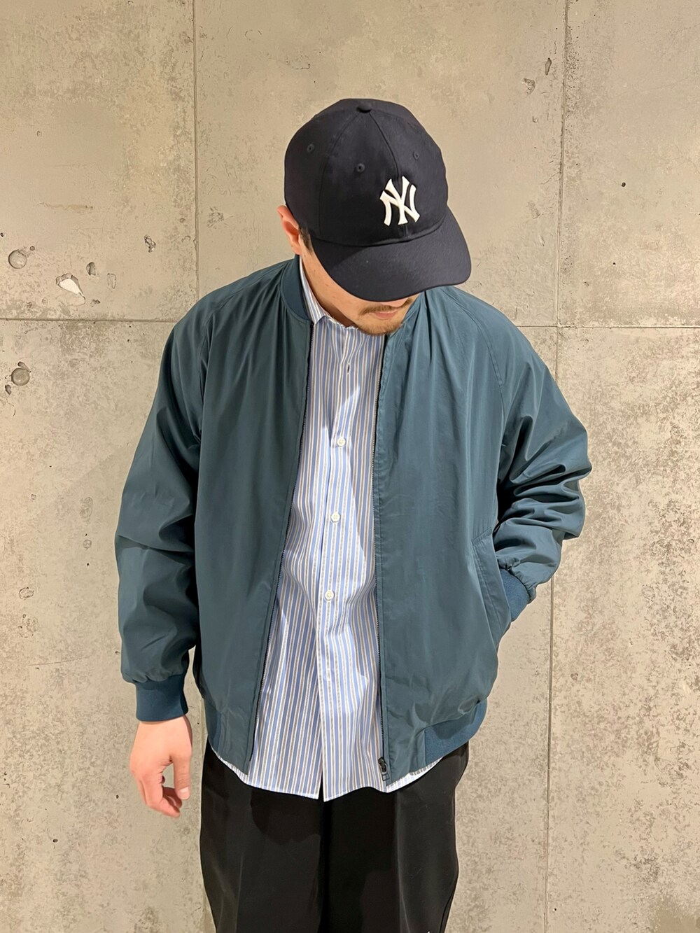 ブルー系のブルゾン、ブラック系のチノパンツ、ブルー系のシャツ/ブラウスを着用したメンズの冬コーディネートの2枚目の写真