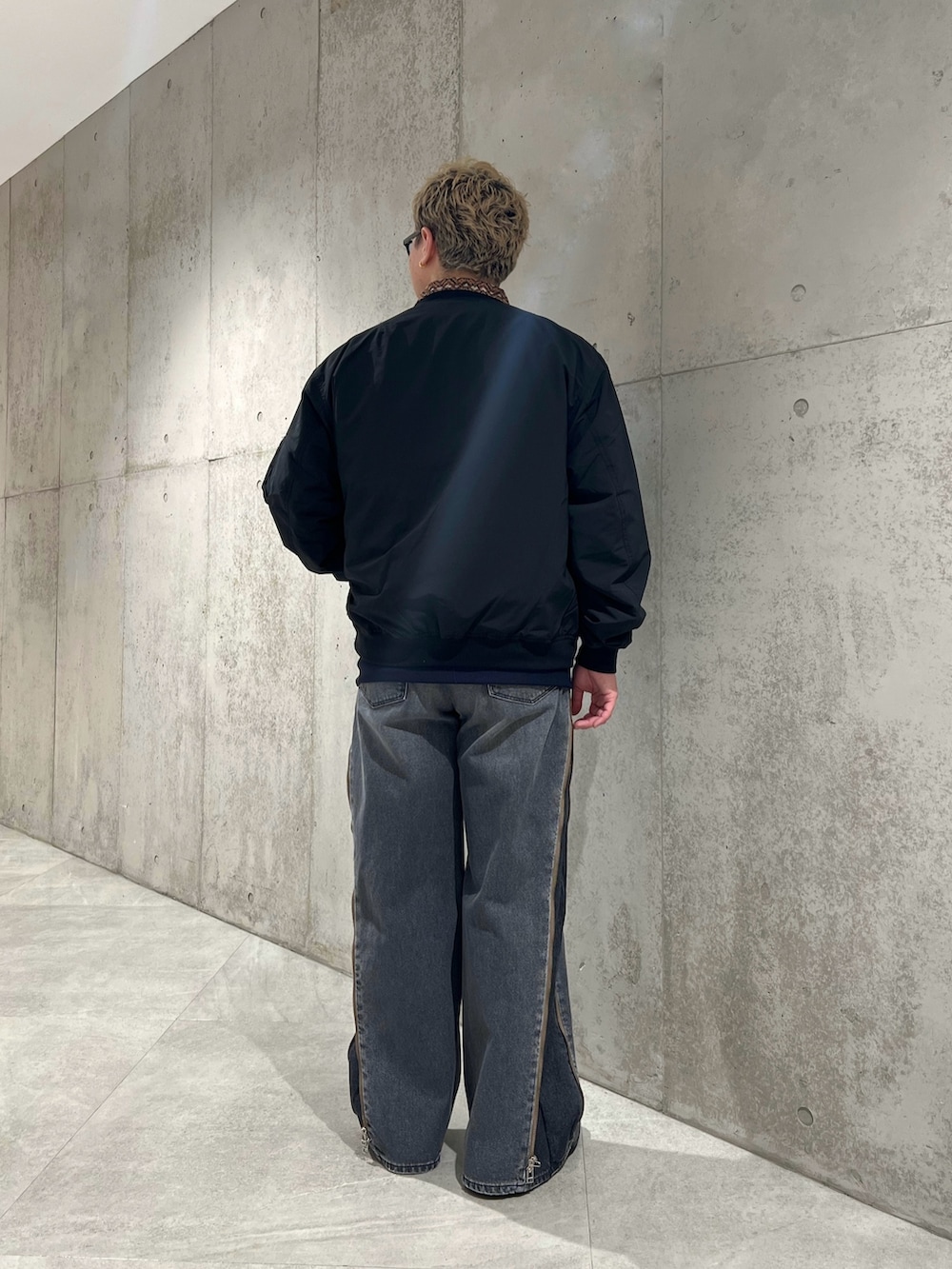 ブラック系のデニムパンツ、ブルー系のブルゾン、ブラック系のMA-1を着用したメンズの春コーディネートの3枚目の写真