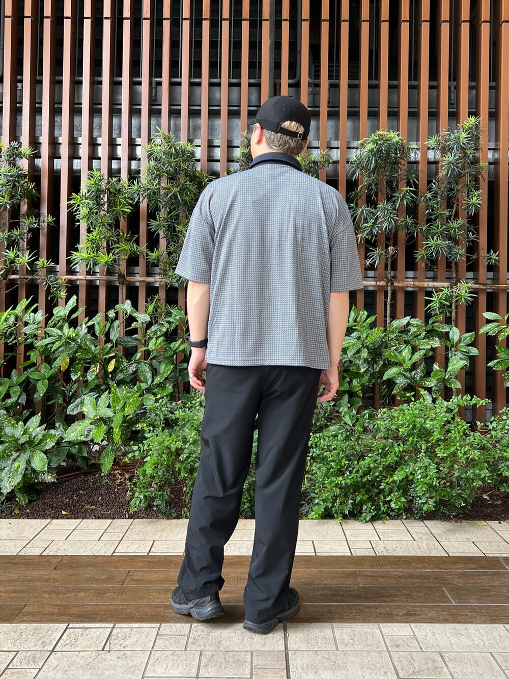 ブラック系のその他パンツ、ブルー系のポロシャツ、ブラック系のシューズを着用したメンズの春コーディネートの4枚目の写真