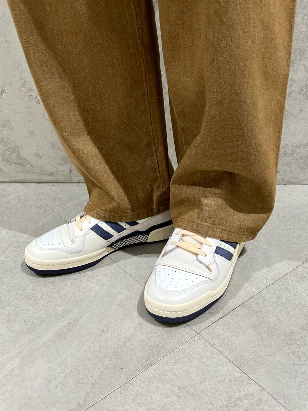 グリーン系のカバーオール、ベージュ系のTシャツ/カットソー、ブラウン系のデニムパンツを着用したメンズの秋コーディネートの4枚目の写真