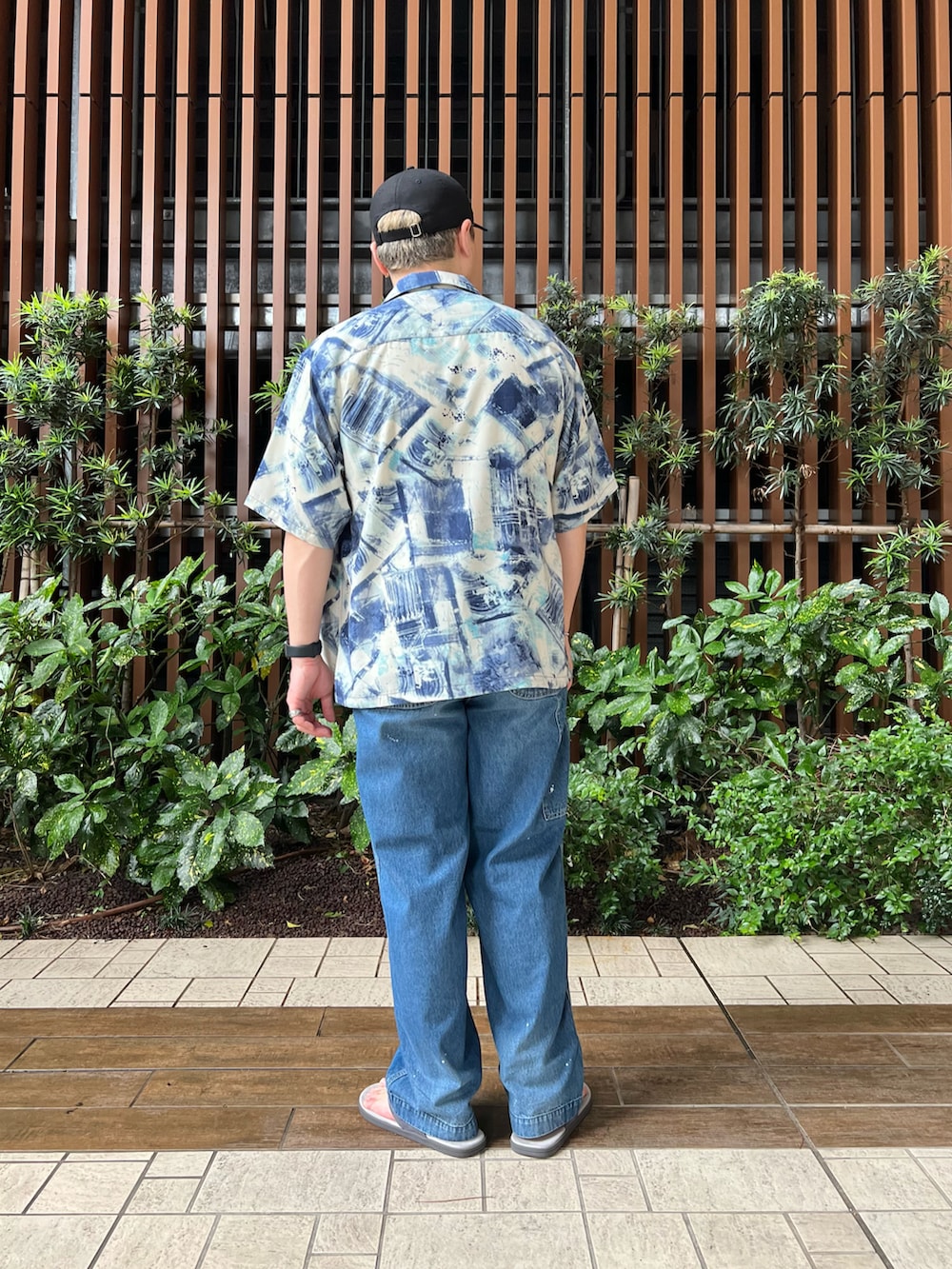 ブルー系のデニムパンツ、ホワイト系のTシャツ/カットソー、グレー系のサンダルを着用したメンズの夏コーディネートの4枚目の写真