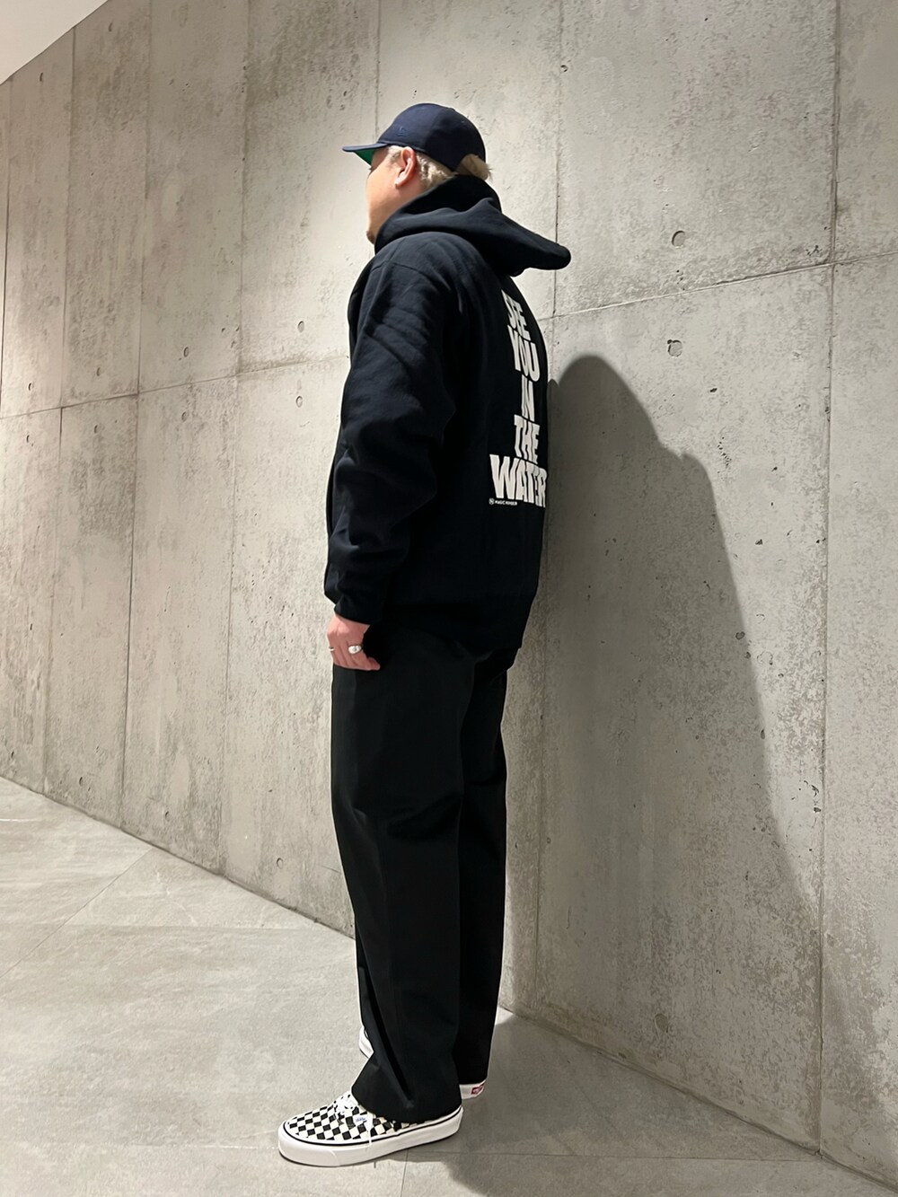 ブラック系のパーカー、ブラック系のチノパンツ、ブラック系のスニーカーを着用したメンズの秋コーディネートの4枚目の写真