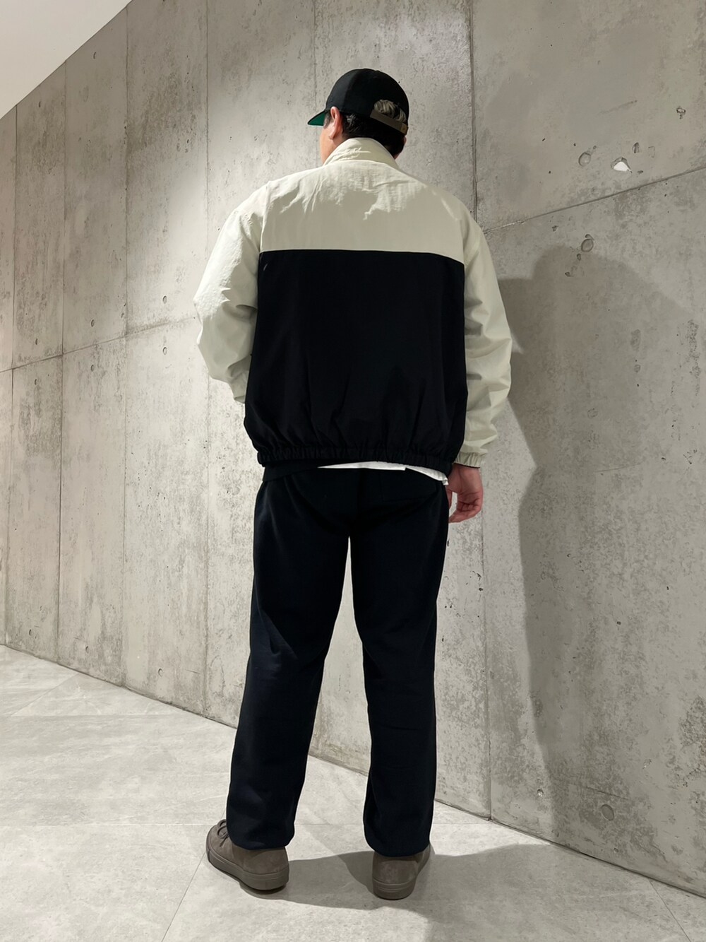 ブラック系のナイロンジャケット、ベージュ系のスニーカー、ブラック系のスウェットを着用したメンズの春コーディネートの4枚目の写真