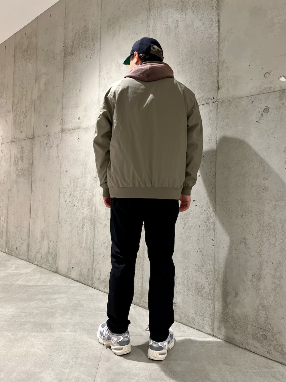 グリーン系のブルゾン、レッド系のパーカー、ブラック系のその他パンツを着用したメンズの春コーディネートの4枚目の写真