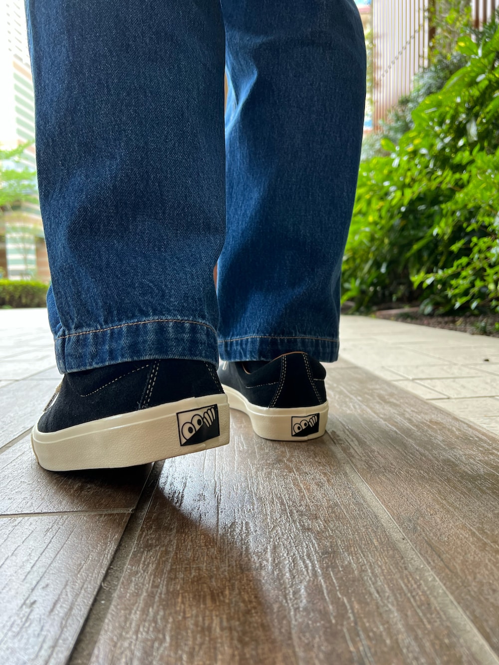 ブラック系のTシャツ/カットソー、ブルー系のデニムパンツ、ブラック系のバックパック/リュックを着用したメンズの春コーディネートの3枚目の写真