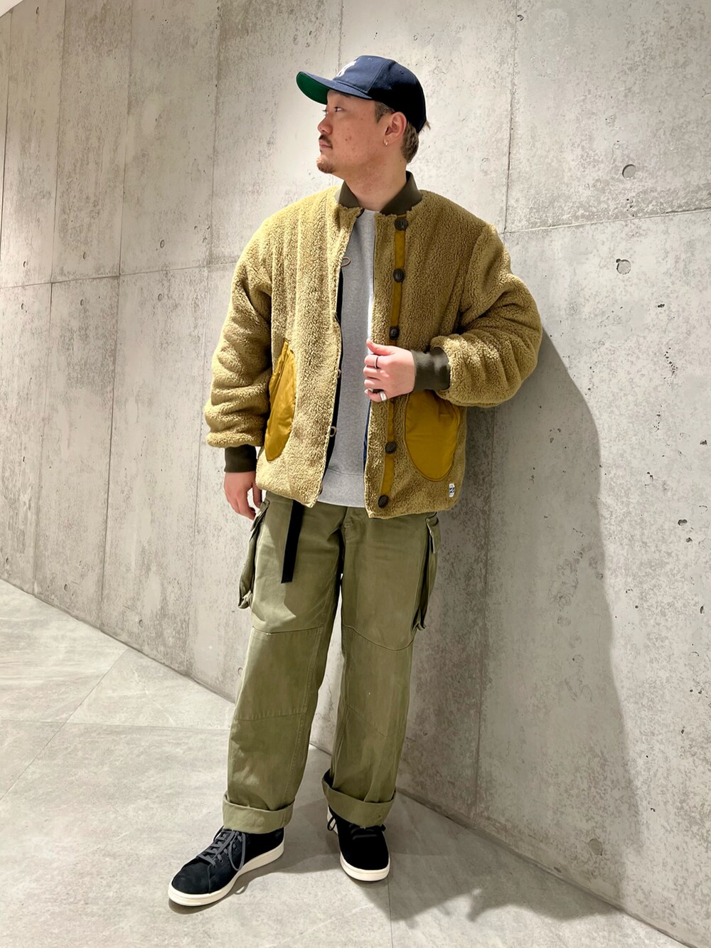 グリーン系のカーゴパンツ、ブルー系のブルゾン、グレー系のスウェットを着用したメンズの秋コーディネートの2枚目の写真