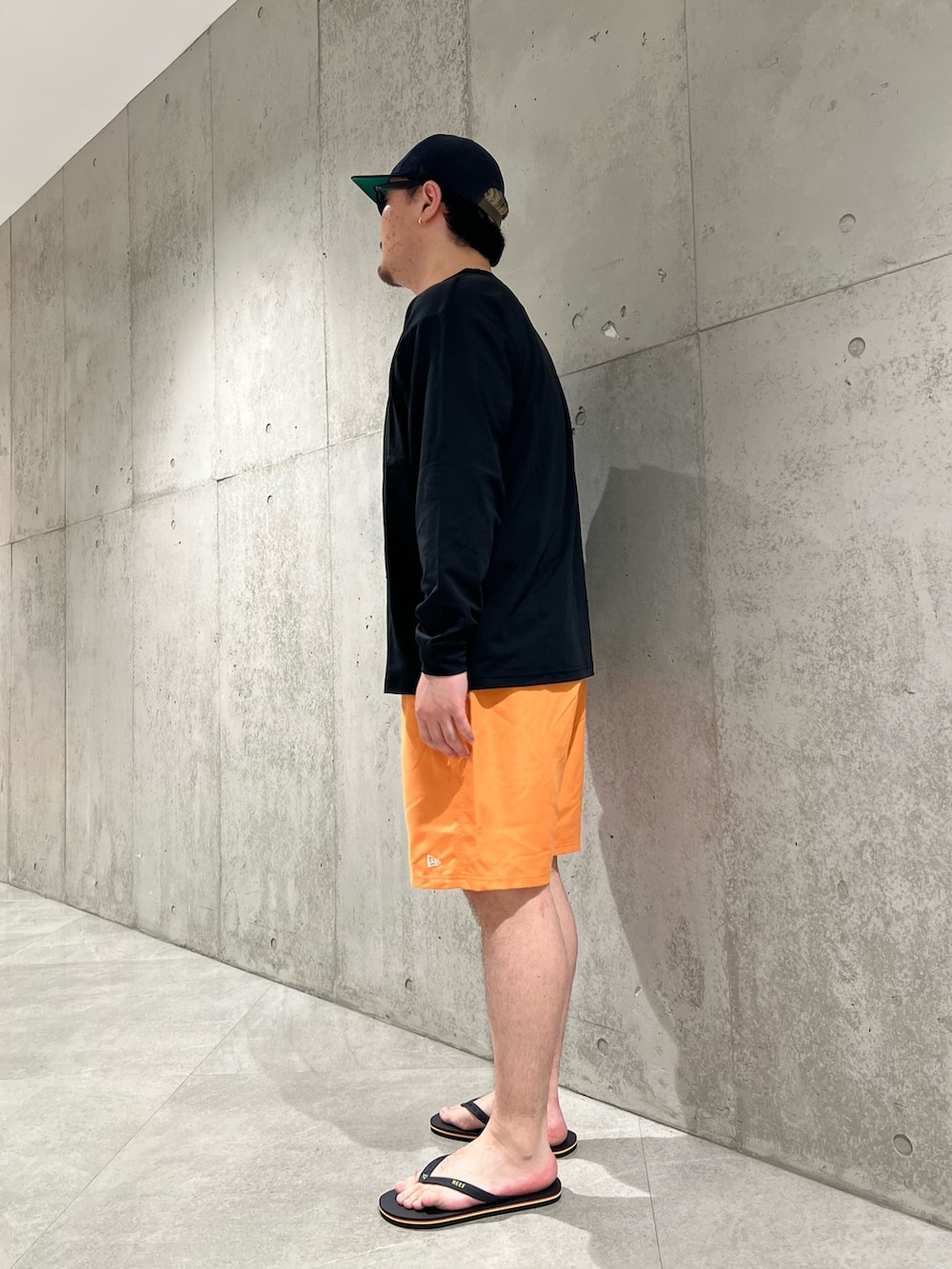 ブラック系のTシャツ/カットソー、オレンジ系のその他パンツ、ブラック系のサンダルを着用したメンズの夏コーディネートの2枚目の写真