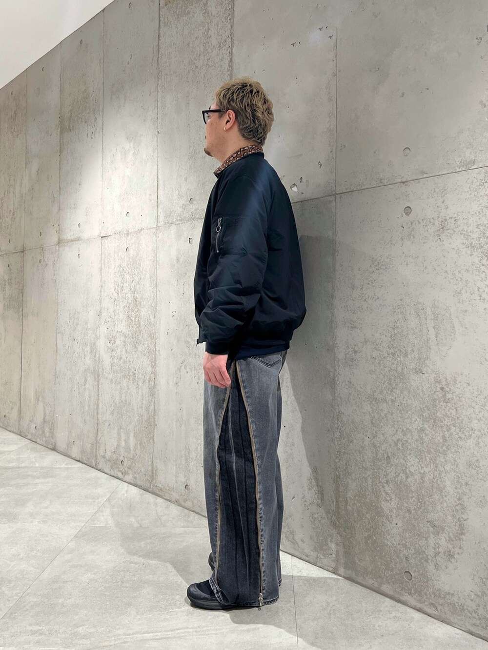 ブラック系のデニムパンツ、ブルー系のブルゾン、ブラック系のMA-1を着用したメンズの春コーディネートの2枚目の写真