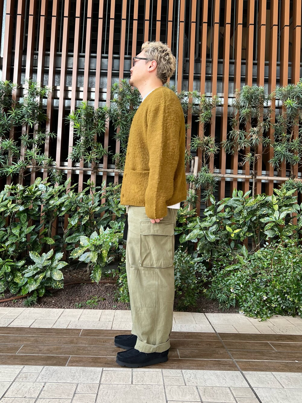 グリーン系のカーゴパンツ、ブラック系のブーツ、ホワイト系のTシャツ/カットソーを着用したメンズの秋コーディネートの3枚目の写真