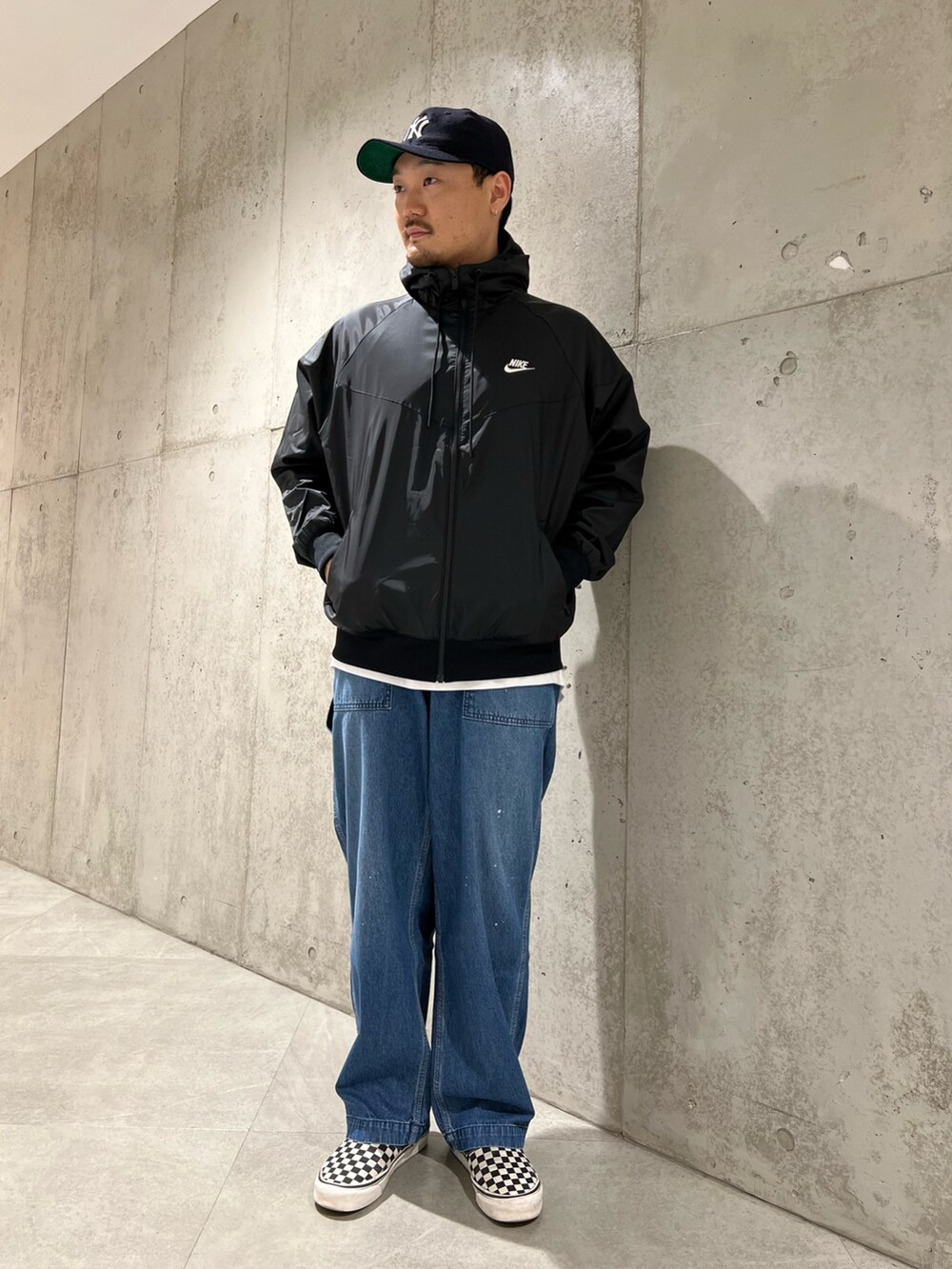 ブルー系のデニムパンツ、ブラック系のブルゾン、ブラック系のTシャツ/カットソーを着用したメンズの春コーディネートの2枚目の写真