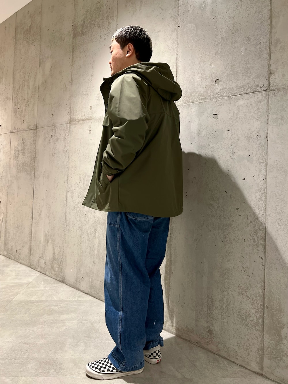 グリーン系のマウンテンパーカー、グレー系のスウェット、その他のスリッポンを着用したメンズの春コーディネートの4枚目の写真