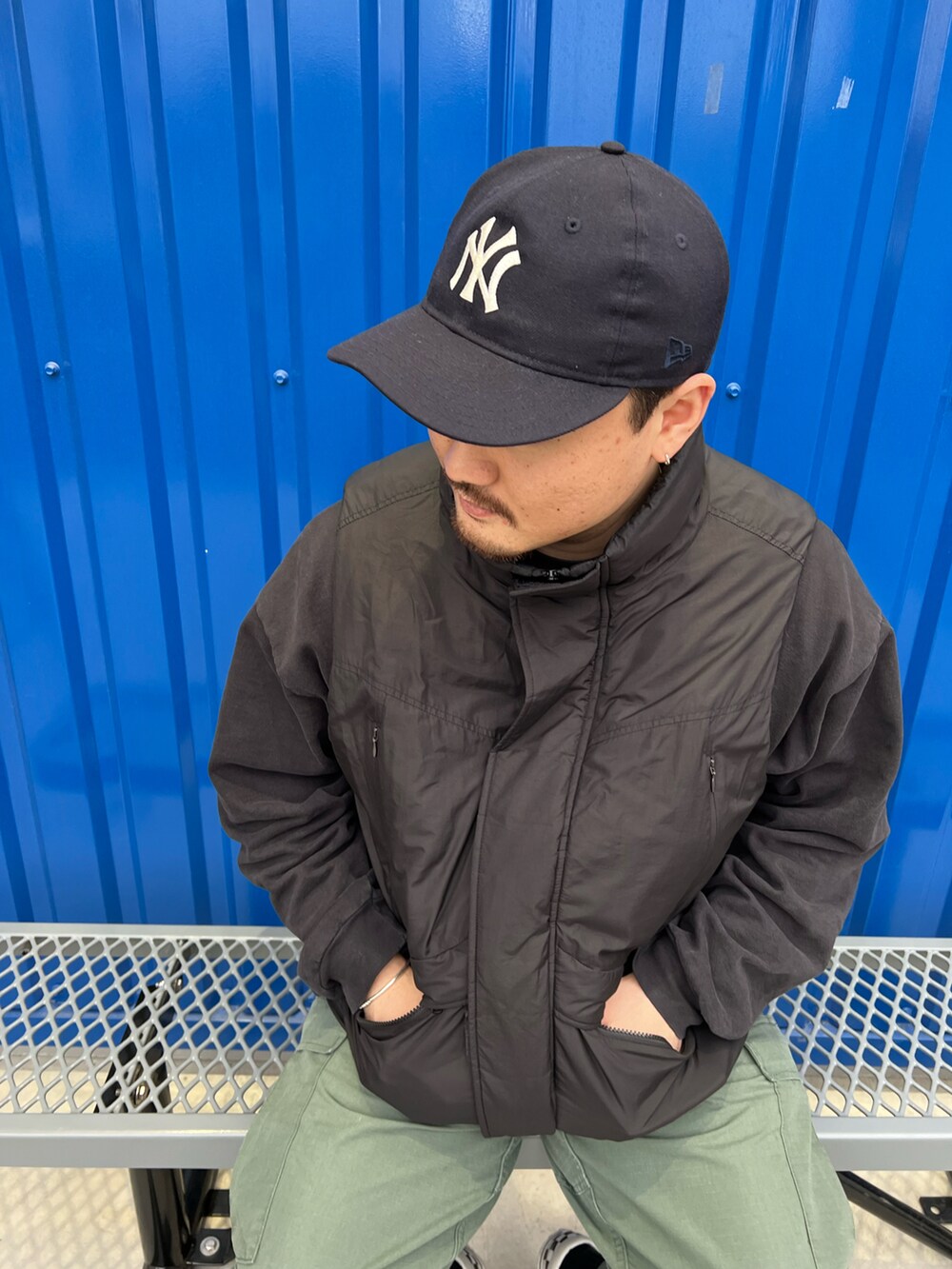 ブラック系のダウンベスト、その他のスリッポン、ブラック系のスウェットを着用したメンズの春コーディネートの2枚目の写真