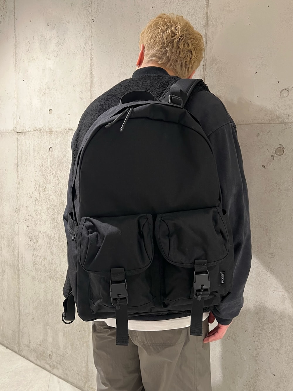 ブラック系のスウェット、ブラック系のその他アウター、ホワイト系のTシャツ/カットソーを着用したメンズの冬コーディネートの4枚目の写真