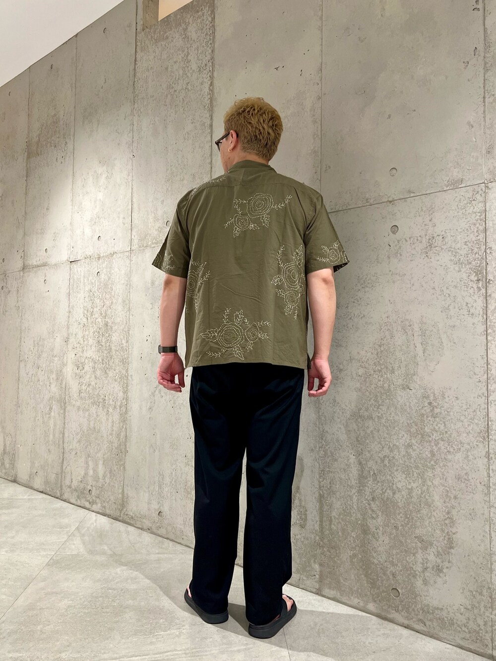 ブラック系のパンツ、グリーン系のシャツ/ブラウス、ブラック系のサンダルを着用したメンズの夏コーディネートの3枚目の写真