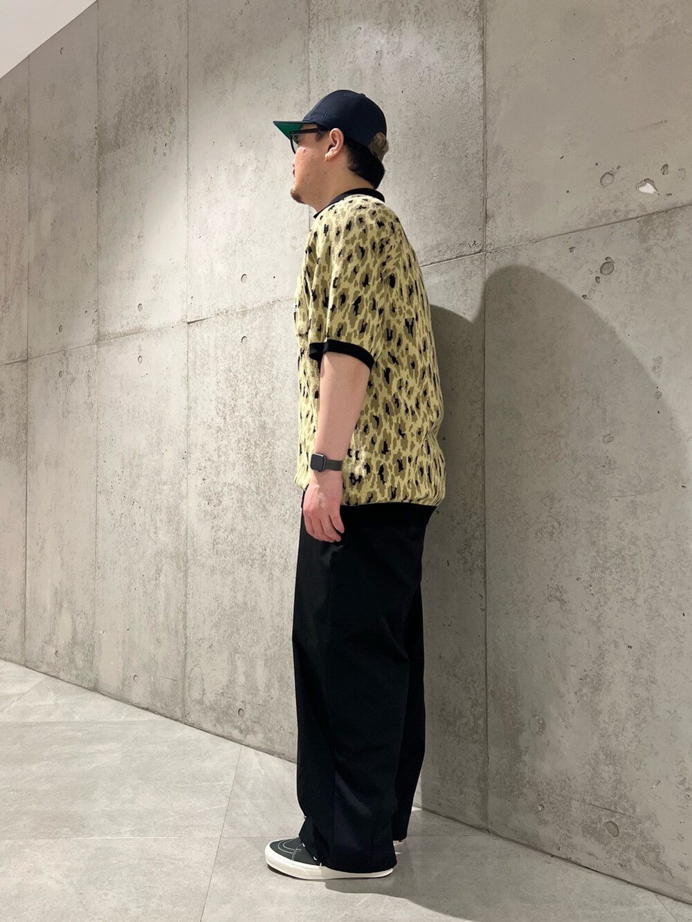 グリーン系のポロシャツ、ブラック系のその他パンツ、ブラック系のスニーカーを着用したメンズの春コーディネートの2枚目の写真