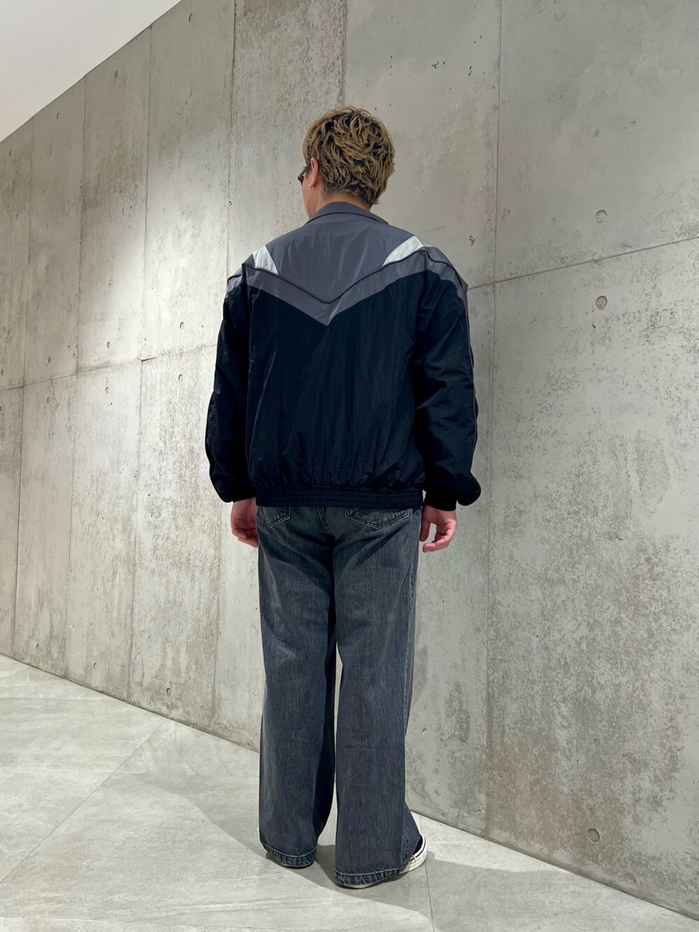 ブラック系のナイロンジャケット、グレー系のTシャツ/カットソー、ブラック系のデニムパンツを着用したメンズの夏コーディネートの3枚目の写真