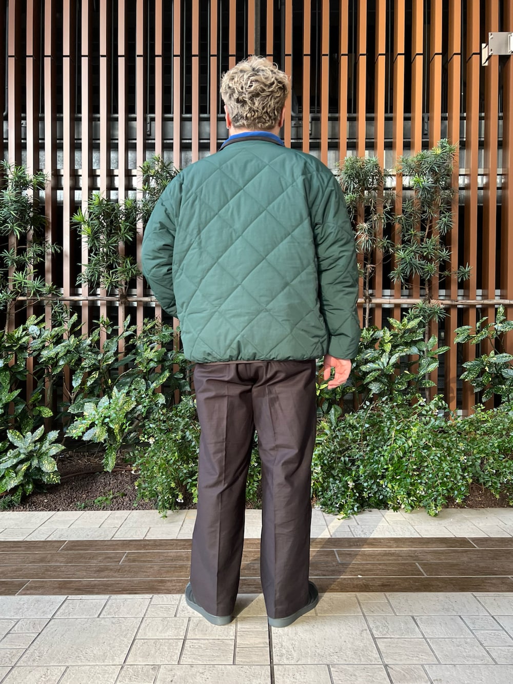 グリーン系のブルゾン、ホワイト系のTシャツ/カットソー、ブラック系のその他パンツを着用したメンズの冬コーディネートの3枚目の写真