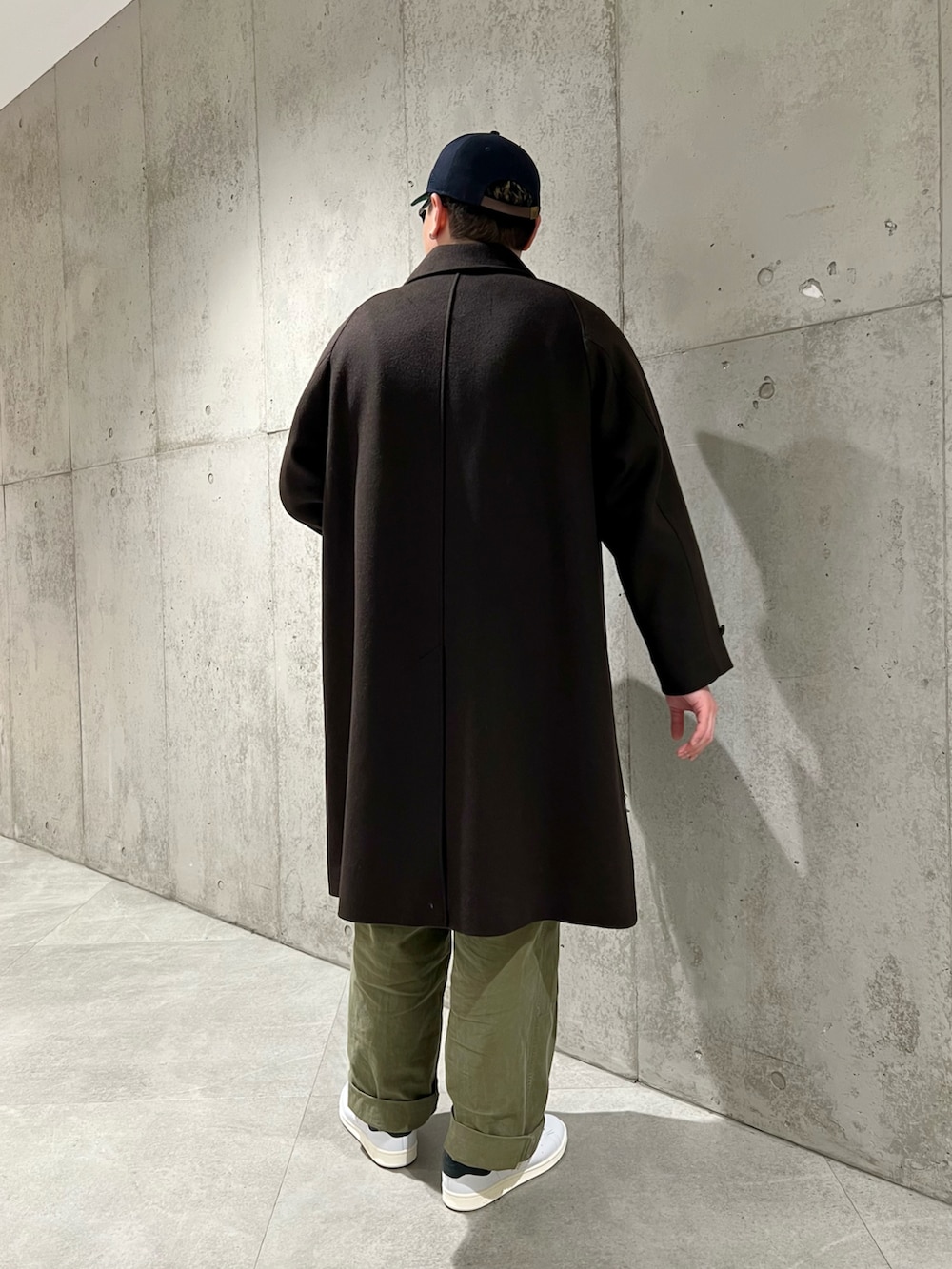 ホワイト系のスニーカー、ブラウン系のその他アウター、ブラウン系のニット/セーターを着用したメンズの冬コーディネートの4枚目の写真