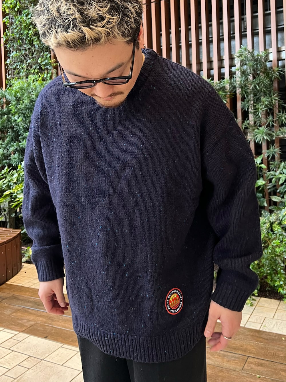 ブルー系のニット/セーター、ブラック系のその他パンツ、レッド系のモカシン/デッキシューズを着用したメンズの秋コーディネートの4枚目の写真
